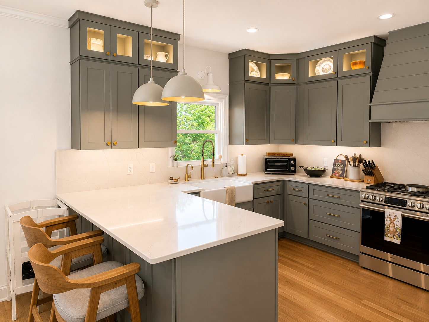 Sage grey shaker kitchen with brass hardware, glass upper cabinets, and quartz counters