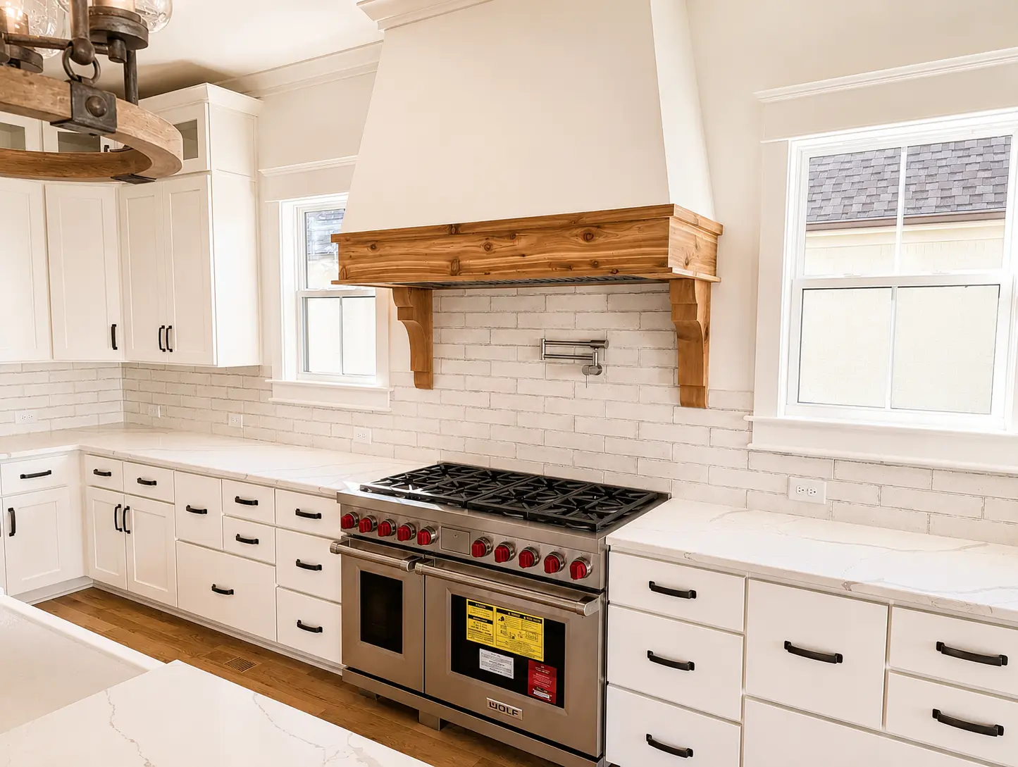 White kitchen cabinetry with a custom plaster and cedar range hood