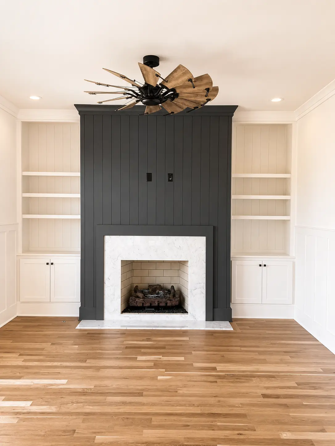 Built-in bookcases and cabinetry flanking a charcoal fireplace surround